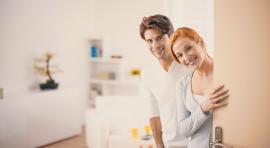 Image d'un couple accueillant ouvrant la porte pour illustrer l'achat immobilier entre particuliers