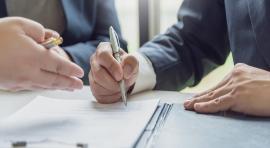 Un client et un conseiller examinent sur papier quel loyer est approprié pour son investissement en Denormandie 