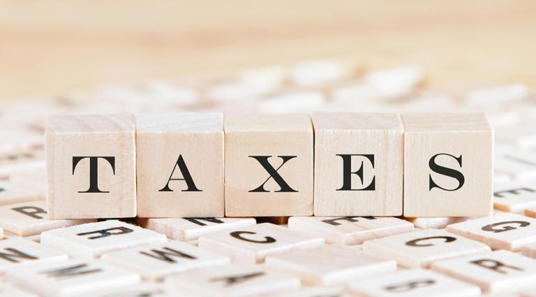 Cubes de lettres formant le mot « taxes » pour illustrer les nouveaux barèmes des impôts 2021
